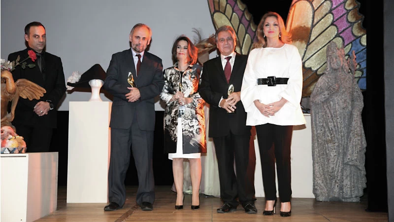  Η υφυπουργός Πολιτισμού Άντζελα Γκερέκου απονέμει, υπό το βλέμμα του παρουσιαστή Κρατερού Κατσούλη, το 1ο βραβείο καλύτερης παράστασης στην Αρχοντούλα Παπαπαναγιώτου της πρώην ΕΛΘΕΑ («Κουρδιστό πορτοκάλι»), το 2ο στον θεατρικό επιχειρηματία Κάρολο Παυλάκη («Πουπουλένιος») και το 3ο στον καλλιτεχνικό διευθυντή του Εθνικού Θεάτρου Σωτήρη Χατζάκη («Δεκαήμερο»)